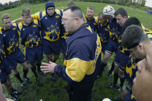 031022-N-6477M-384  Smokey Point, Wash. (Oct 22, 2003) -- U.S. Navy rugby team head coach, Cmdr. Don Sheehan, assigned to Naval Air Station (NAS) Patuxent River, Md. instructs the team before their first match against the U.S. Air force at the Naval Support Center in Washington.  U.S. Navy photo by PhotographerÕs Mate 2nd Class Eli Jody Medellin.  (RELEASED)